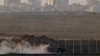 An Israeli armoured personnel carrier (APC) manoeuvres on the Israeli side of the border with Gaza